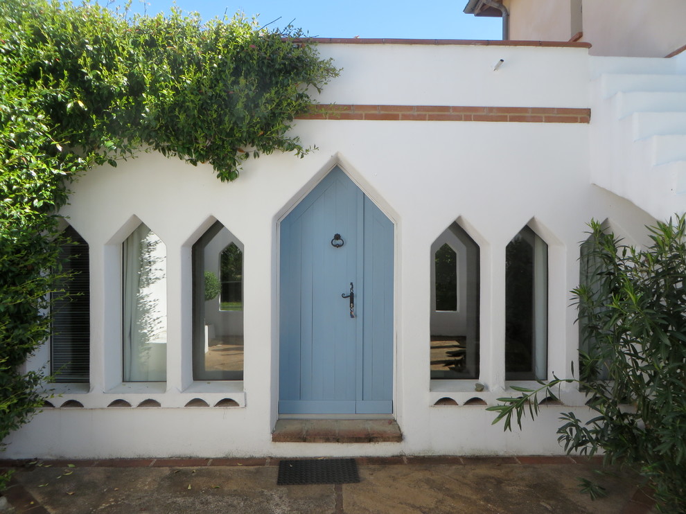 Exemple d'une façade de maison blanche méditerranéenne en pierre de taille moyenne et de plain-pied avec un toit plat.