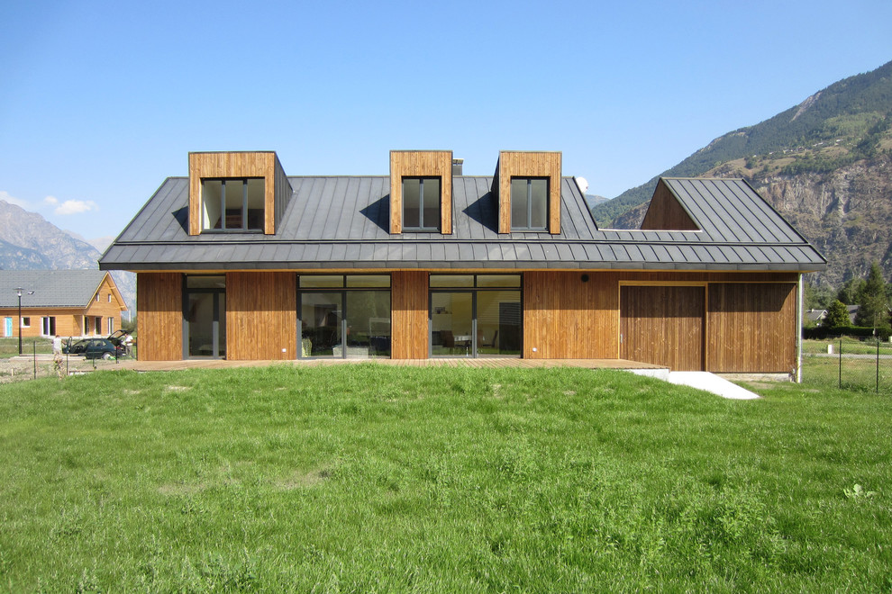 Foto de fachada contemporánea de dos plantas con revestimiento de madera y tejado a dos aguas