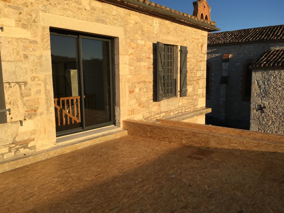 Foto de fachada de casa beige mediterránea grande con revestimiento de piedra y tejado de teja de barro