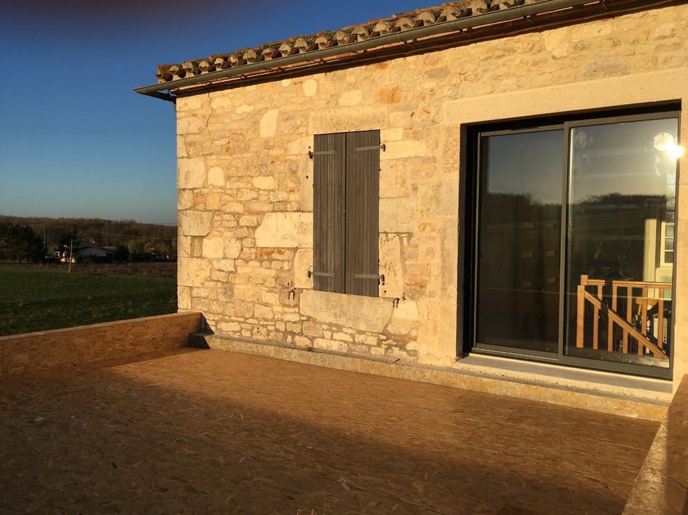 This is an example of a large and beige mediterranean detached house in Toulouse with stone cladding and a tiled roof.