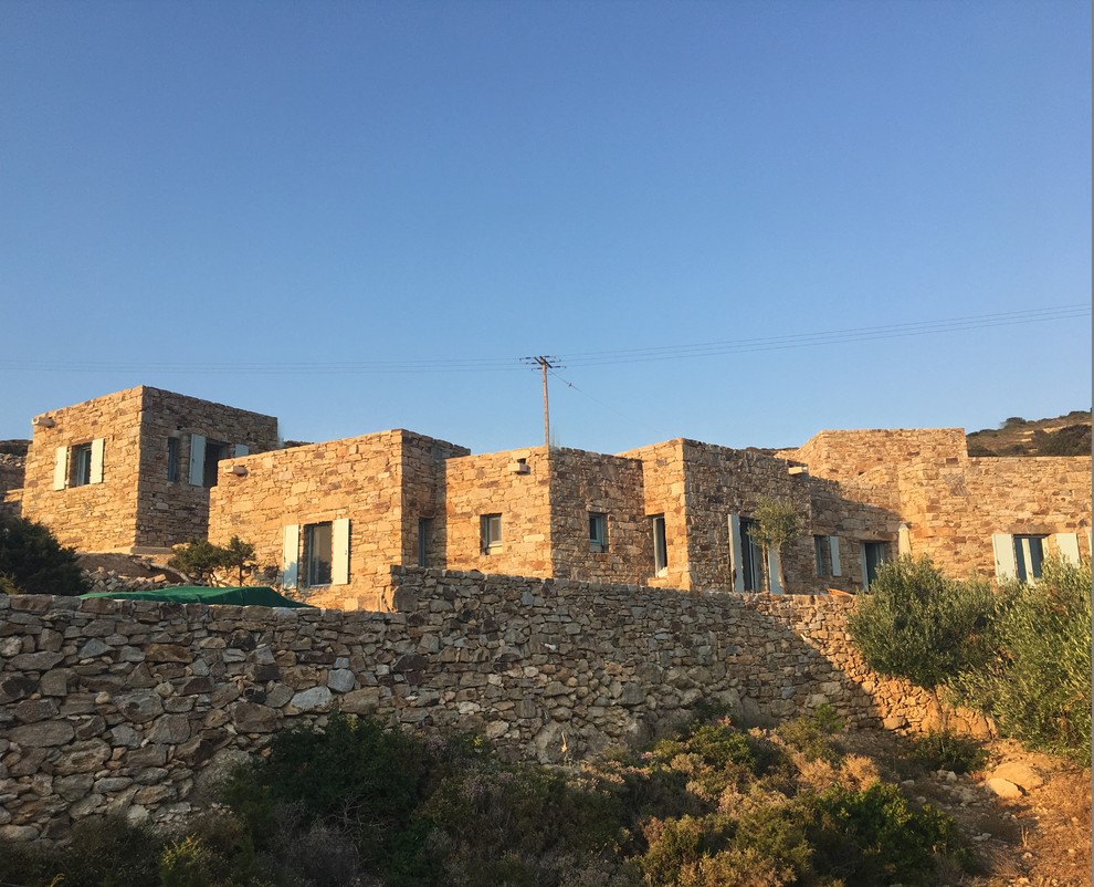 Imagen de fachada de casa beige mediterránea extra grande de una planta con revestimiento de piedra