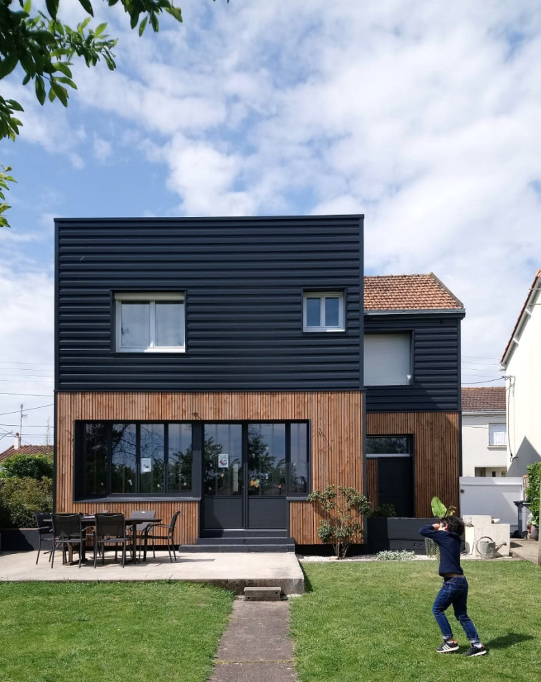 На фото: двухэтажный, деревянный, черный таунхаус среднего размера в современном стиле с крышей-бабочкой, черепичной крышей, красной крышей и отделкой планкеном с