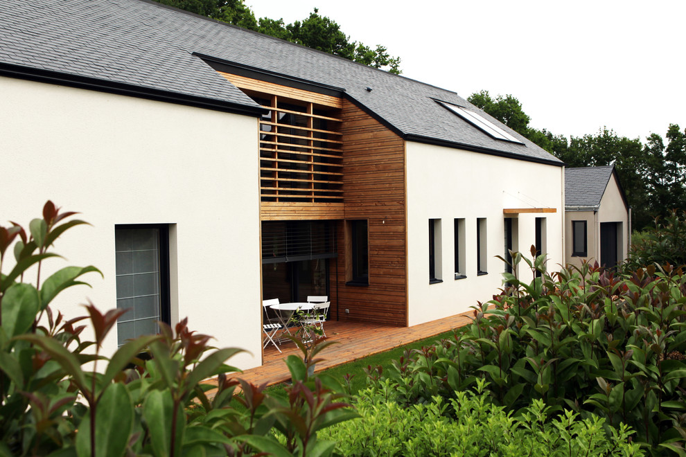 Ejemplo de fachada de casa blanca tradicional de tamaño medio de dos plantas con revestimientos combinados y tejado a dos aguas