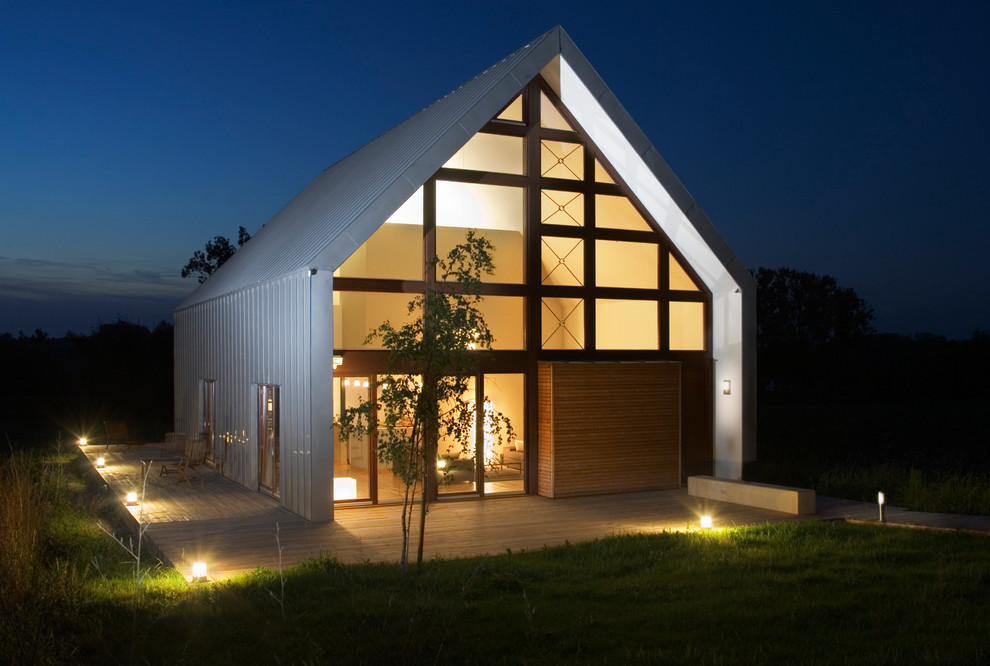 Esempio della facciata di una casa contemporanea a due piani di medie dimensioni con rivestimento in vetro e tetto a capanna