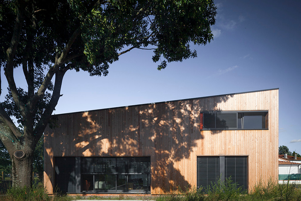 Ejemplo de fachada marrón contemporánea de tamaño medio de dos plantas con revestimiento de madera y tejado de un solo tendido