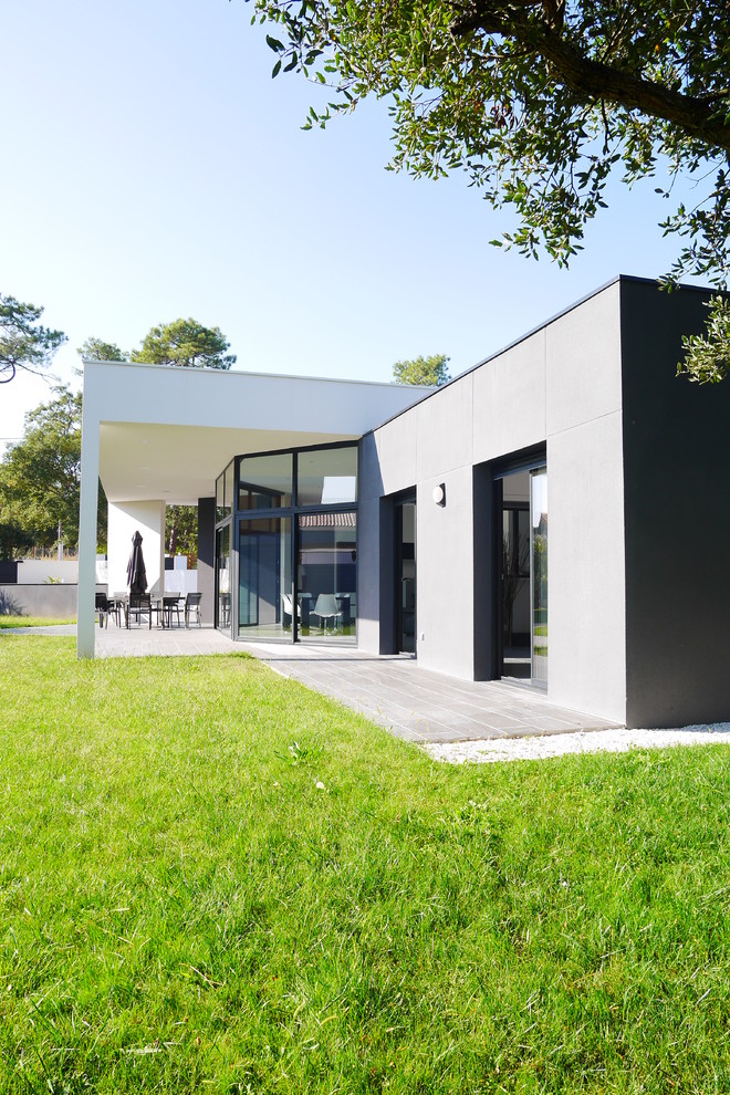 Medium sized and gey contemporary bungalow house exterior in Bordeaux with mixed cladding and a flat roof.