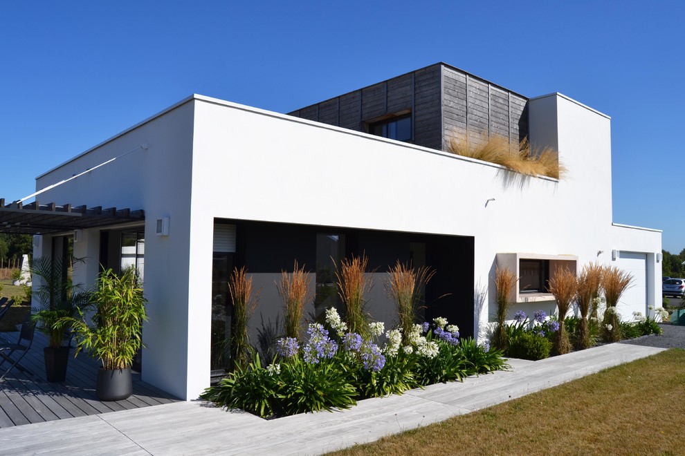 Immagine della facciata di una casa bianca contemporanea a due piani con rivestimenti misti e tetto piano