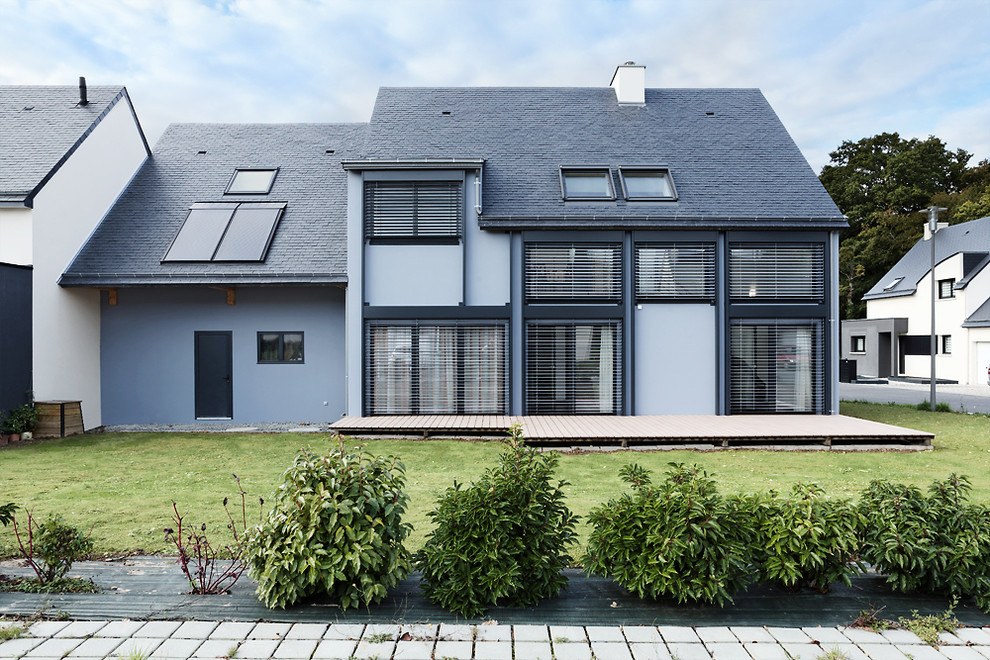 Réalisation d'une petite façade de maison bleue design en verre à un étage avec un toit à deux pans.