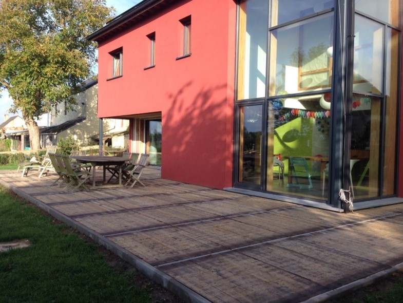 Exemple d'une façade de maison rouge tendance en stuc à un étage avec un toit à deux pans.