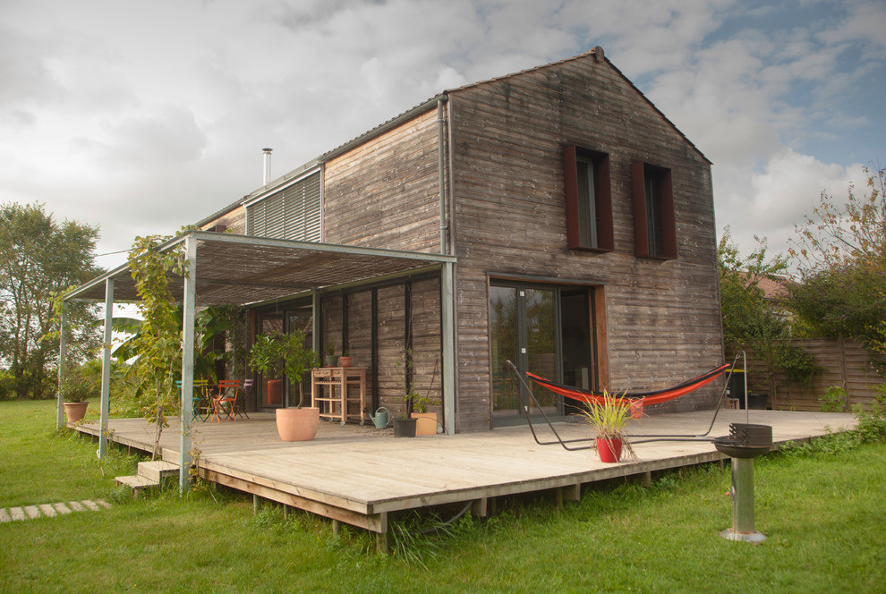 Réalisation d'une façade de maison design en bois à un étage et de taille moyenne avec un toit à deux pans.