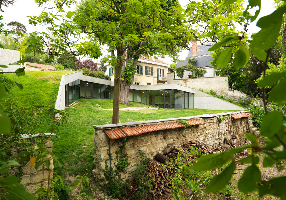 На фото: большой, двухэтажный, белый таунхаус в современном стиле с облицовкой из бетона, плоской крышей и зеленой крышей