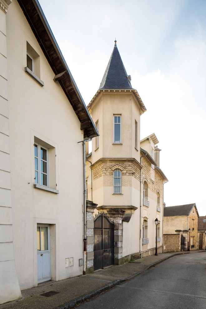 Dreistöckiges Klassisches Reihenhaus mit Steinfassade, beiger Fassadenfarbe, Walmdach und Ziegeldach in Paris