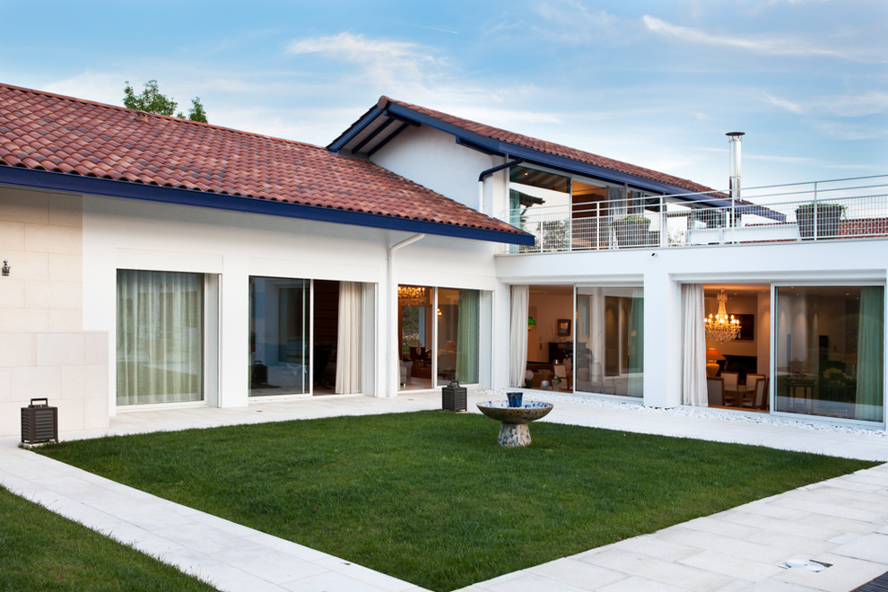 На фото: двухэтажный, белый вилла среднего размера в стиле модернизм с двускатной крышей