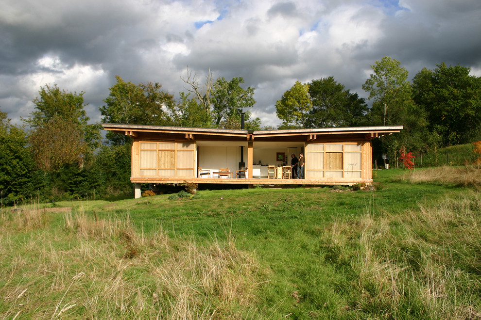 Esempio della facciata di una casa contemporanea a un piano di medie dimensioni con rivestimento in legno e tetto piano