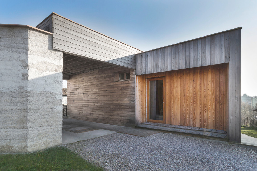 Diseño de fachada marrón actual de tamaño medio de una planta con revestimiento de madera y tejado plano