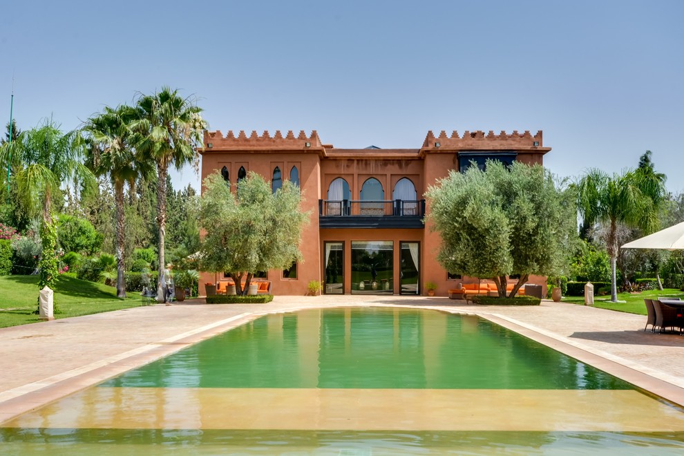 Foto della facciata di una casa marrone mediterranea a due piani con rivestimento in adobe e tetto piano