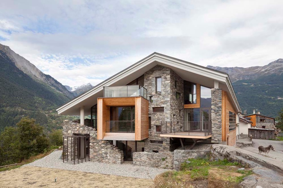 Cette image montre une grande façade de maison design à deux étages et plus avec un toit à deux pans et un revêtement mixte.