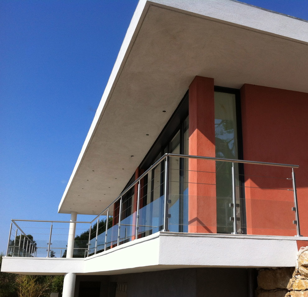 Idée de décoration pour une façade de maison rouge design à niveaux décalés avec un toit plat.