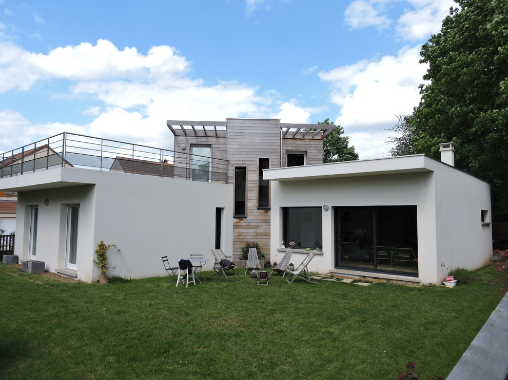 Aménagement d'une grande façade de maison contemporaine avec un toit plat.