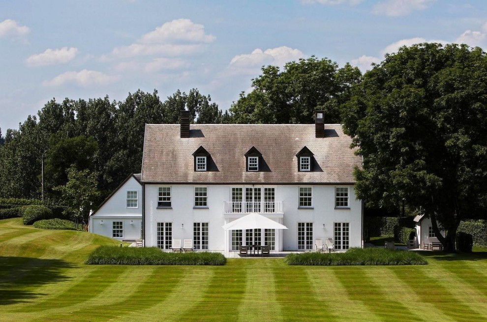 Cette image montre une très grande façade de maison blanche traditionnelle à deux étages et plus avec un toit à deux pans.