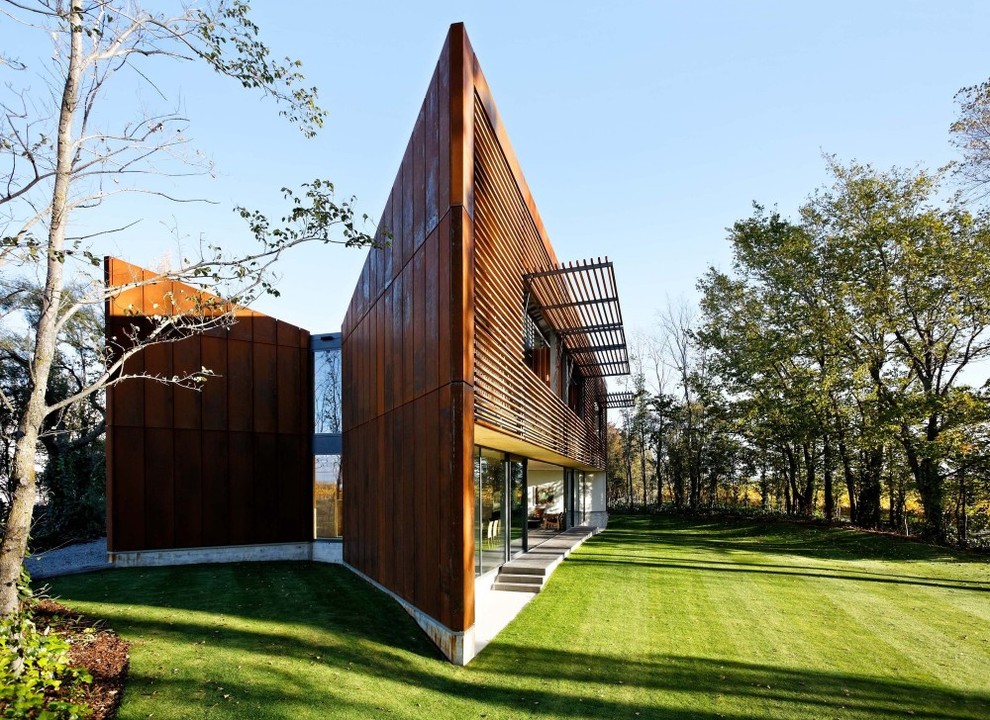 На фото: трехэтажный, деревянный, коричневый, большой дом в современном стиле с плоской крышей