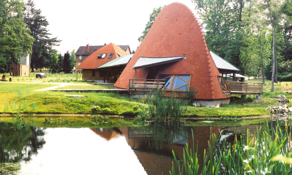 Источник вдохновения для домашнего уюта: одноэтажный, оранжевый частный загородный дом в стиле фьюжн с крышей из гибкой черепицы
