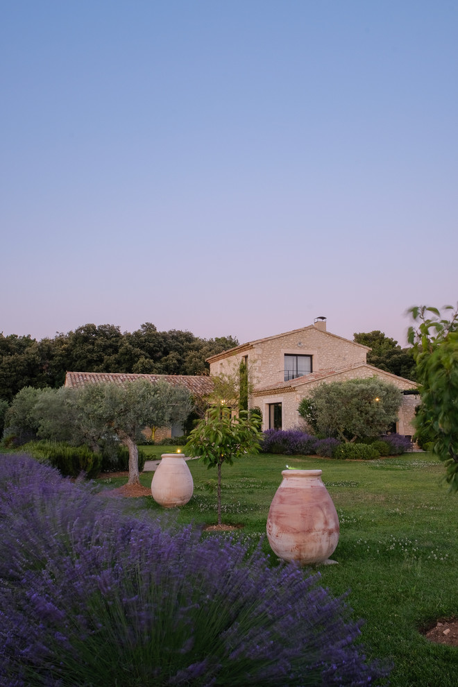 Diseño de fachada de casa beige mediterránea de dos plantas con revestimiento de piedra, tejado a dos aguas y tejado de teja de barro