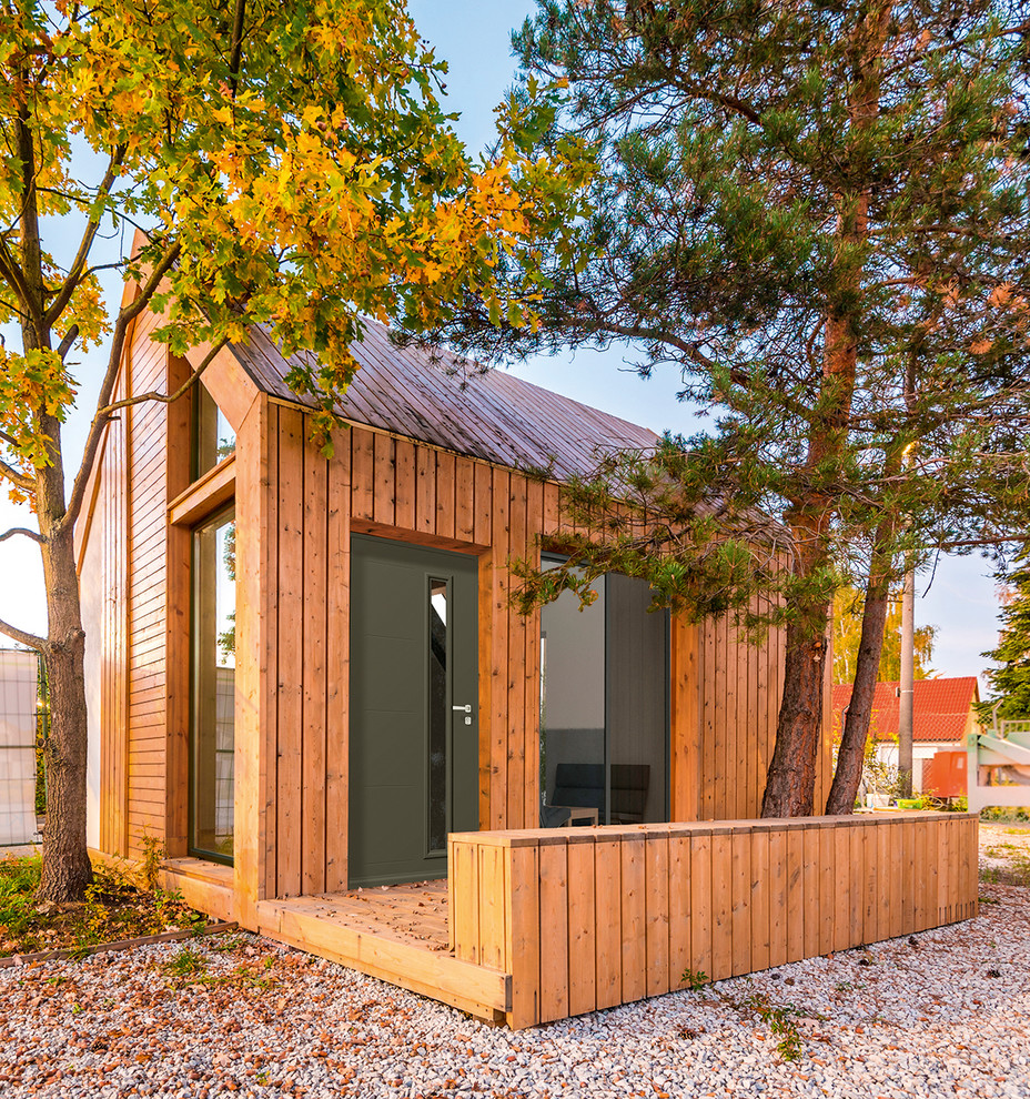 Idee per la facciata di una casa piccola marrone contemporanea a un piano con rivestimento in legno e tetto a capanna