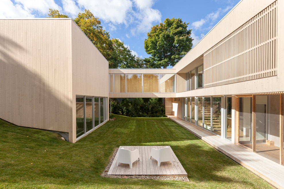 Diseño de fachada de casa beige escandinava de dos plantas con revestimiento de madera y tejado plano