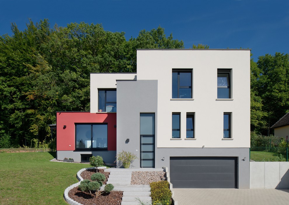 Idées déco pour une façade de maison multicolore contemporaine à niveaux décalés avec un toit plat.