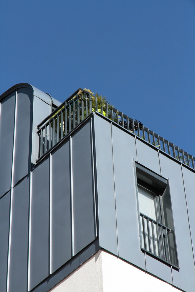 Geräumiges, Dreistöckiges Modernes Wohnung mit Metallfassade, grauer Fassadenfarbe, Satteldach und Blechdach in Paris