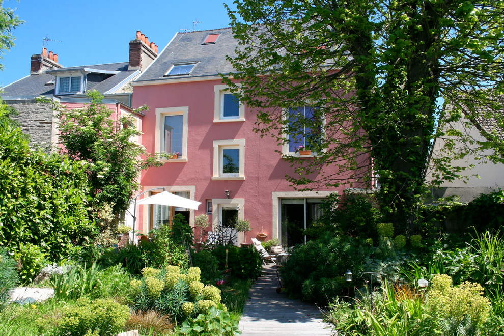 Idées déco pour une façade de maison rose classique de taille moyenne et à deux étages et plus avec un toit à deux pans.
