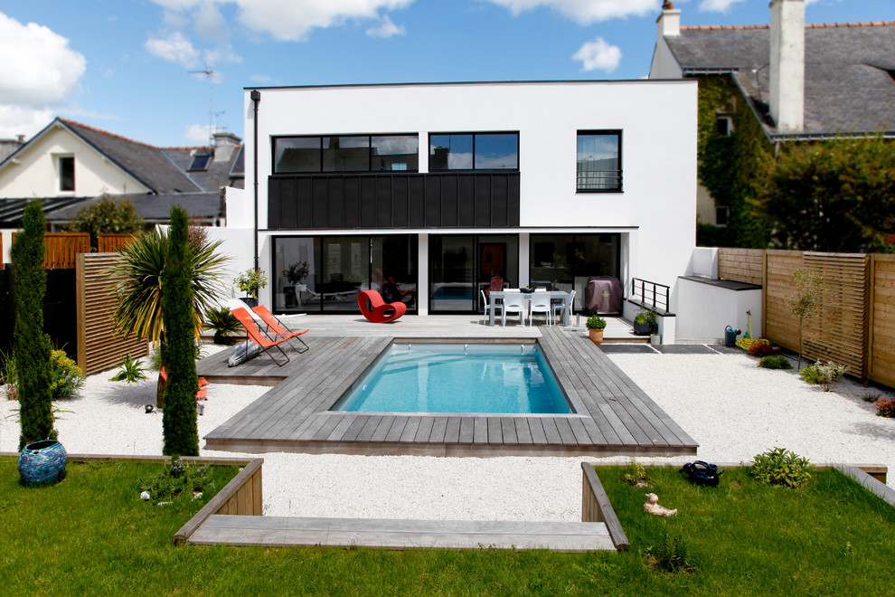 This is an example of a white and medium sized contemporary two floor house exterior in Rennes with a flat roof.