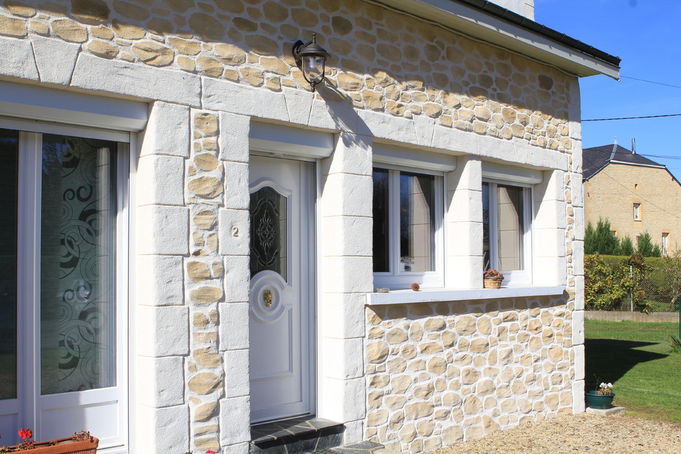 Exemple d'une façade de maison beige moderne.