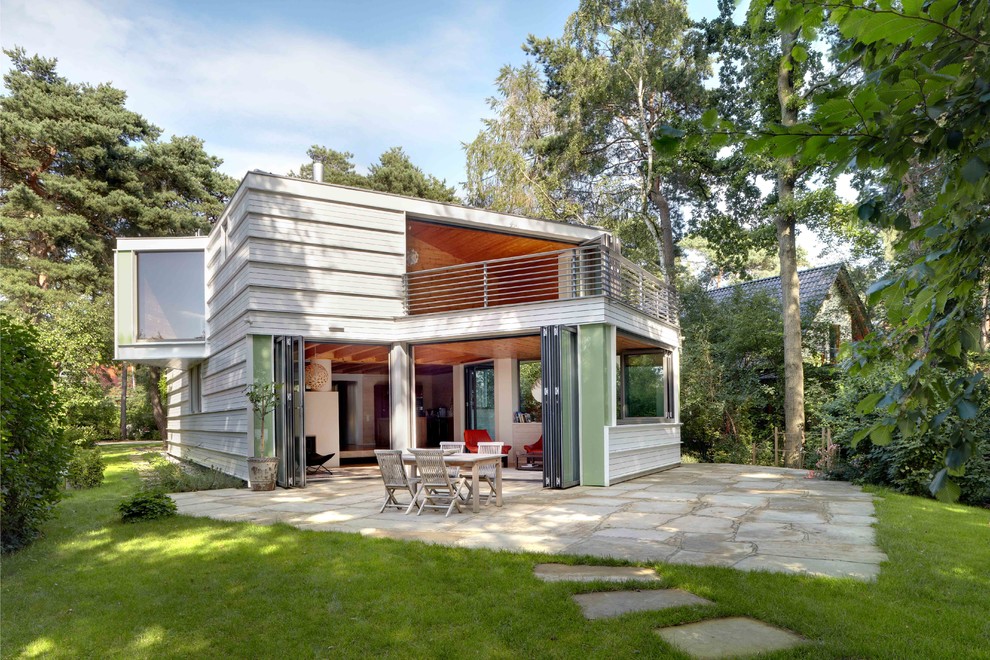 Inspiration pour une façade de maison blanche design en bois de taille moyenne et à un étage avec un toit en appentis.