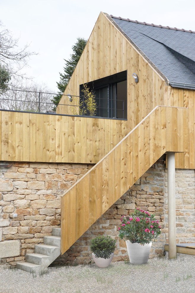 This is an example of a contemporary detached house in Nantes with mixed cladding, a pitched roof and a shingle roof.
