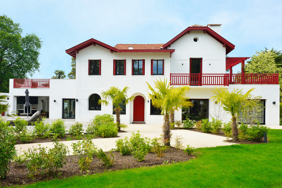 Inspiration for a large tropical white two-story exterior home remodel in Bordeaux