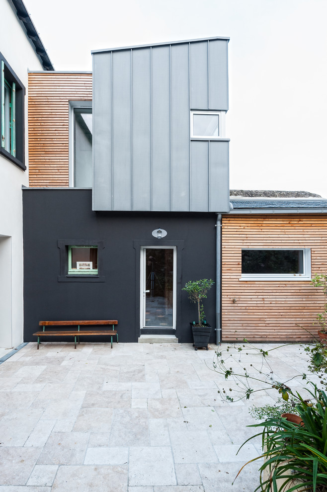 Exemple d'une façade de maison noire tendance de taille moyenne et à un étage avec un revêtement mixte et un toit en appentis.