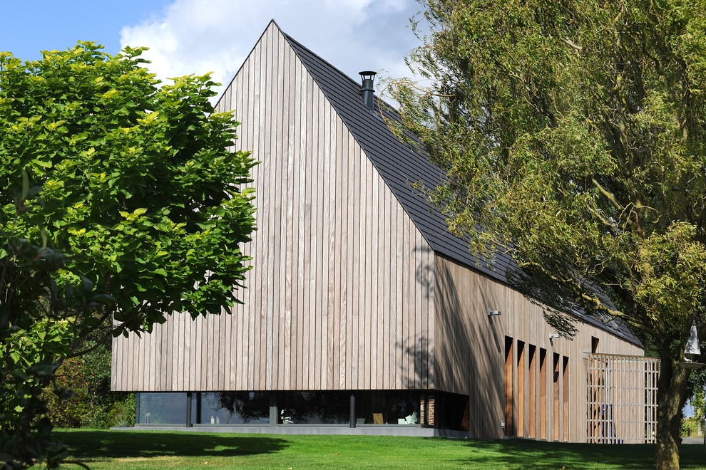 Foto de fachada contemporánea con revestimiento de madera y tejado a dos aguas