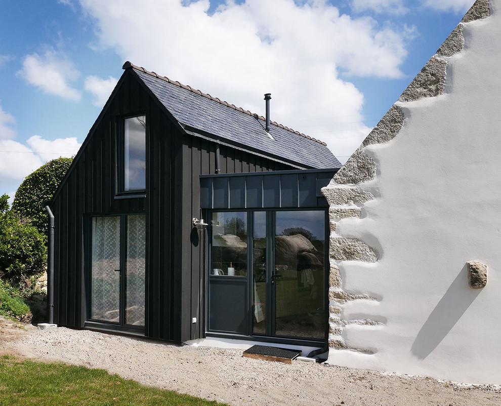 Cette photo montre une façade de maison noire tendance à un étage avec un revêtement mixte et un toit à deux pans.