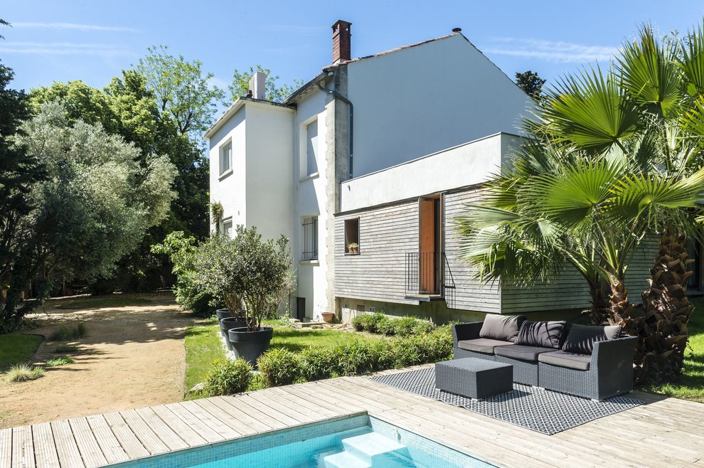 Diseño de fachada de casa multicolor mediterránea con revestimientos combinados, tejado a dos aguas y tejado de teja de barro