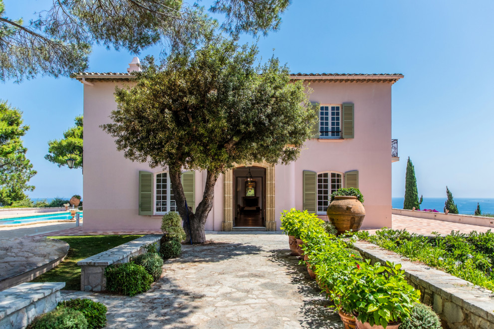 Идея дизайна: двухэтажный, розовый частный загородный дом в средиземноморском стиле с черепичной крышей