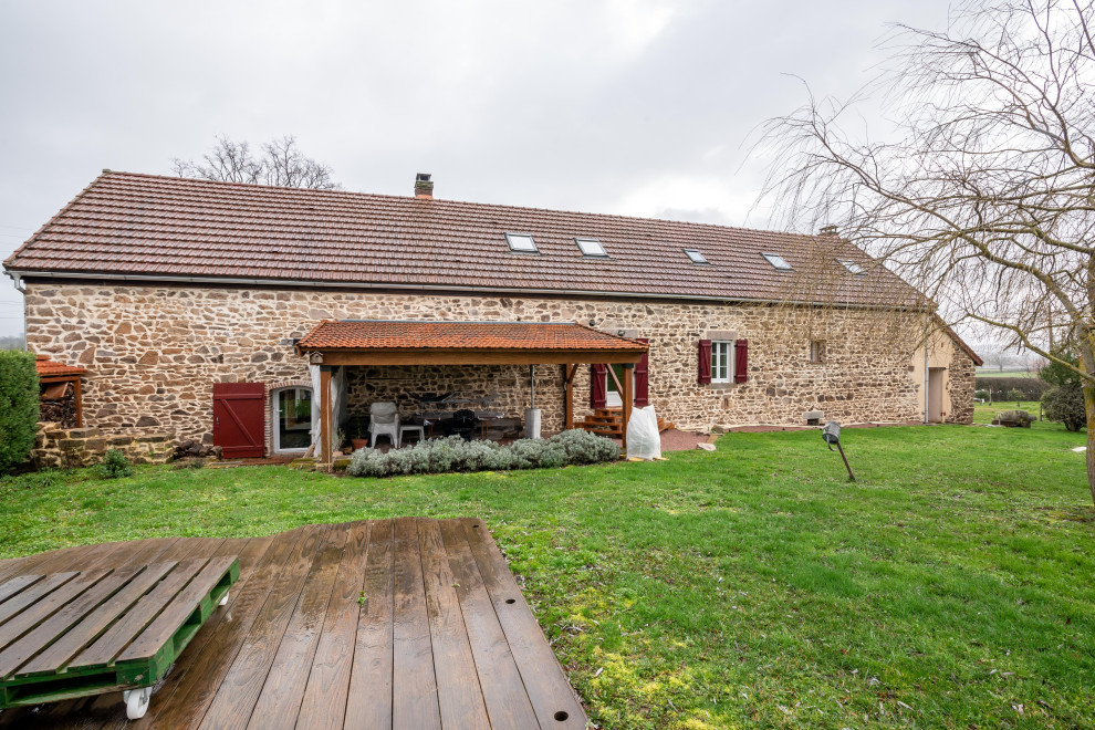 Photo of an expansive and beige country two floor detached house in Dijon with stone cladding, a pitched roof and a mixed material roof.