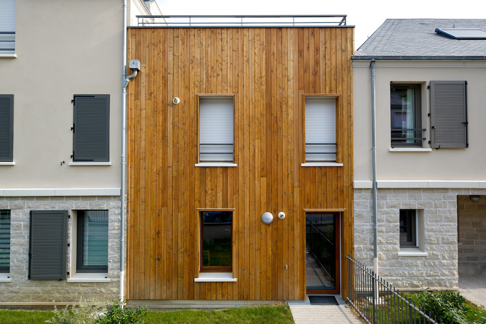 Cette image montre une petite façade de maison marron minimaliste en bois à un étage avec un toit plat.