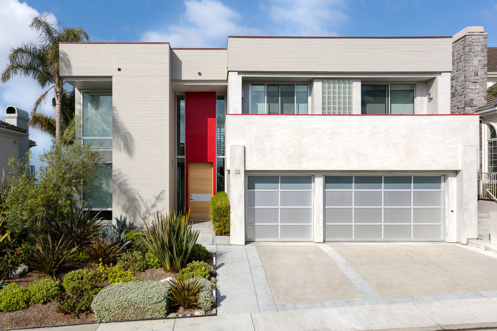 Cette image montre une façade de maison grise design à un étage avec un revêtement mixte et un toit plat.