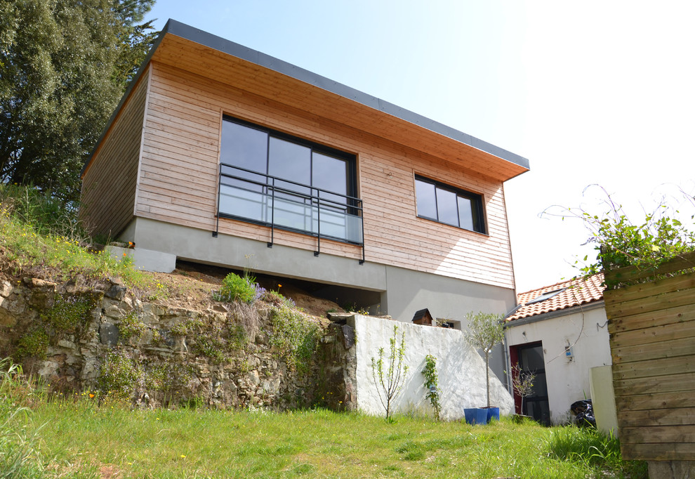Esempio della facciata di una casa marrone contemporanea a tre piani di medie dimensioni con rivestimento in legno e tetto piano