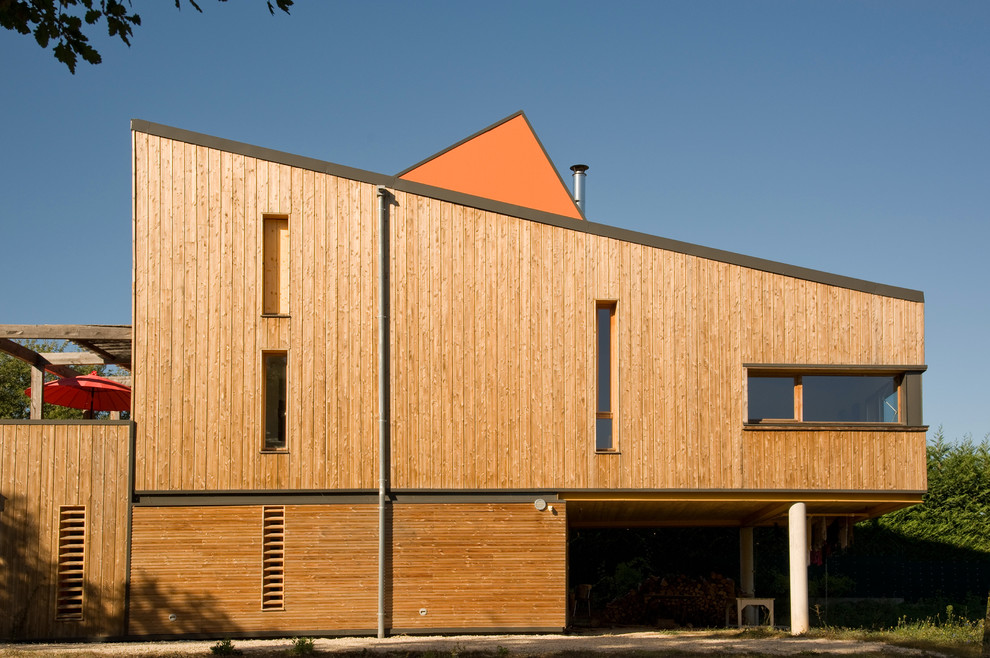 Exemple d'une façade de maison marron tendance en bois de taille moyenne et à deux étages et plus avec un toit en appentis.