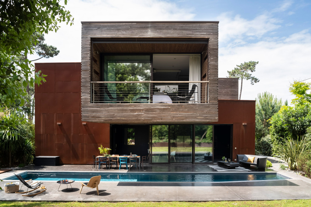 Idées déco pour une façade de maison marron moderne à un étage avec un revêtement mixte et un toit plat.