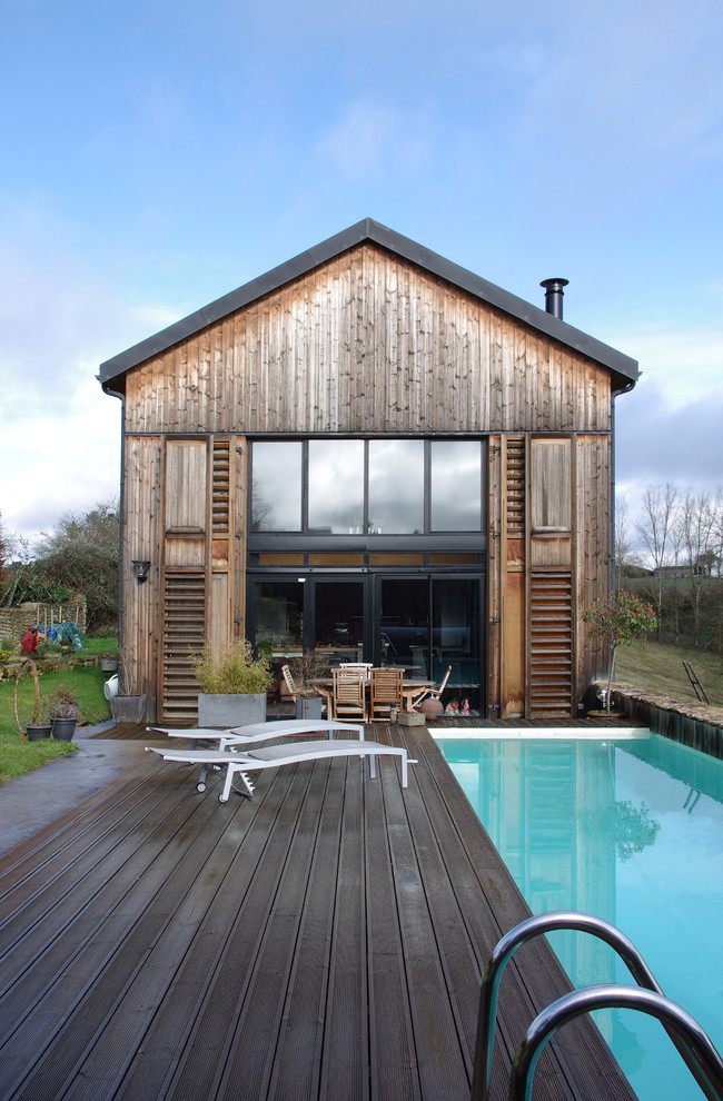 Ejemplo de fachada de casa marrón de estilo de casa de campo de tamaño medio de dos plantas con revestimiento de madera y tejado a dos aguas