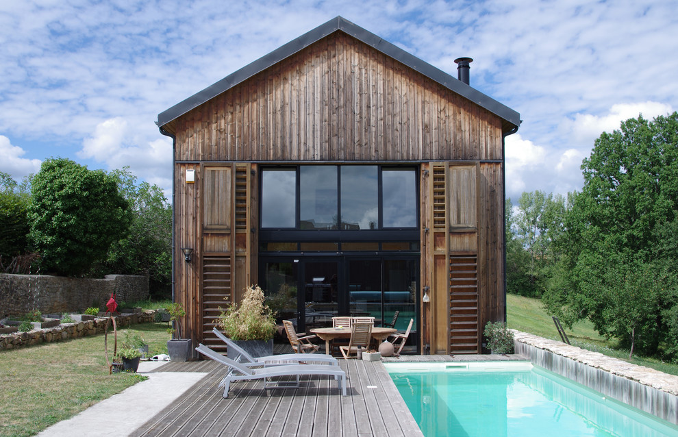 Aménagement d'une façade de maison marron campagne en bois à un étage avec un toit à deux pans.